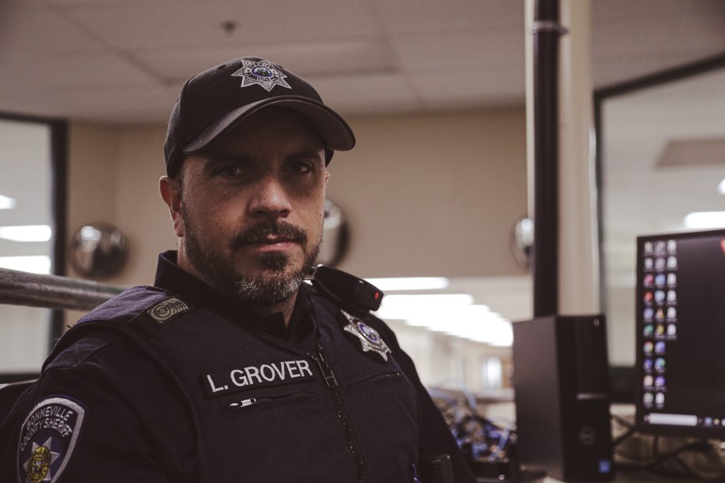 A police officer in uniform seated at a desk