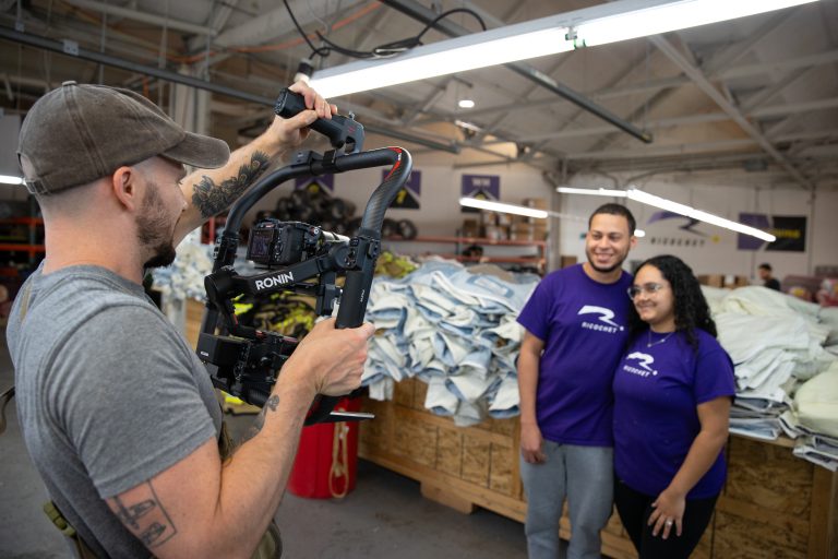 A videographer filming two people on set